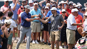 Victor Perez is congratulated by a fan after he plays his shot during the first round of the U.S. Open golf tournament