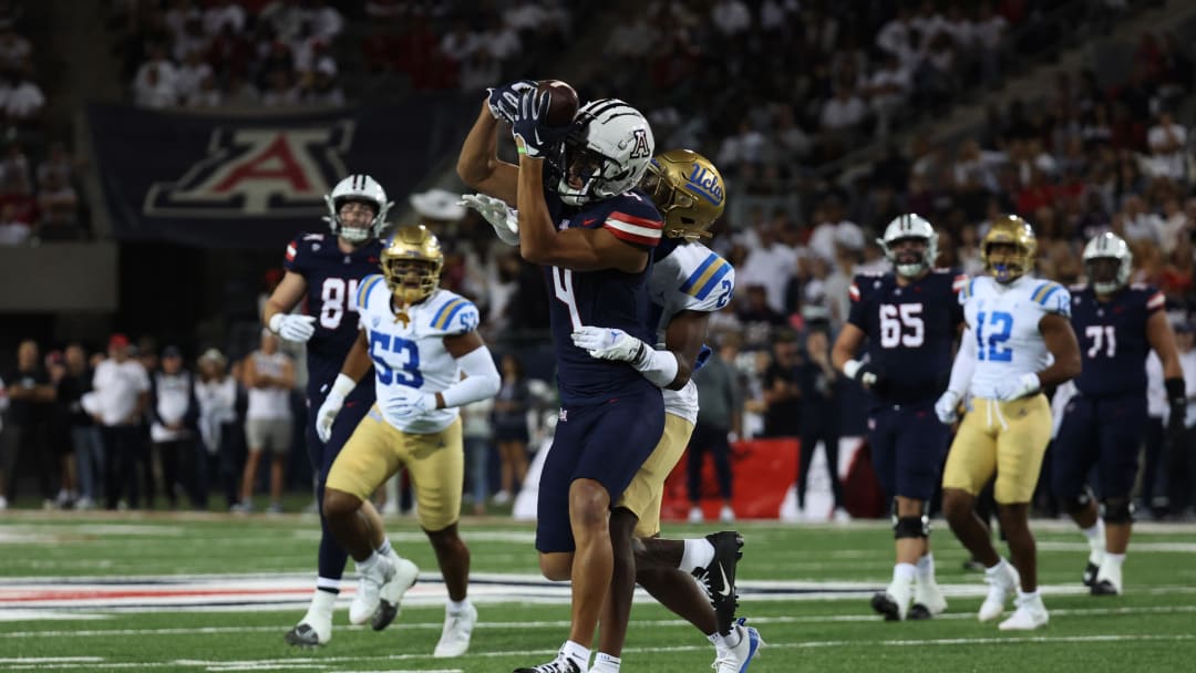 Nov 4, 2023; Tucson, Arizona, USA; Arizona Wildcats wide receiver Tetairoa McMillan #4 makes a catch against UCLA Bruins defensive back Jaylin Davies #24 during the first half at Arizona Stadium.