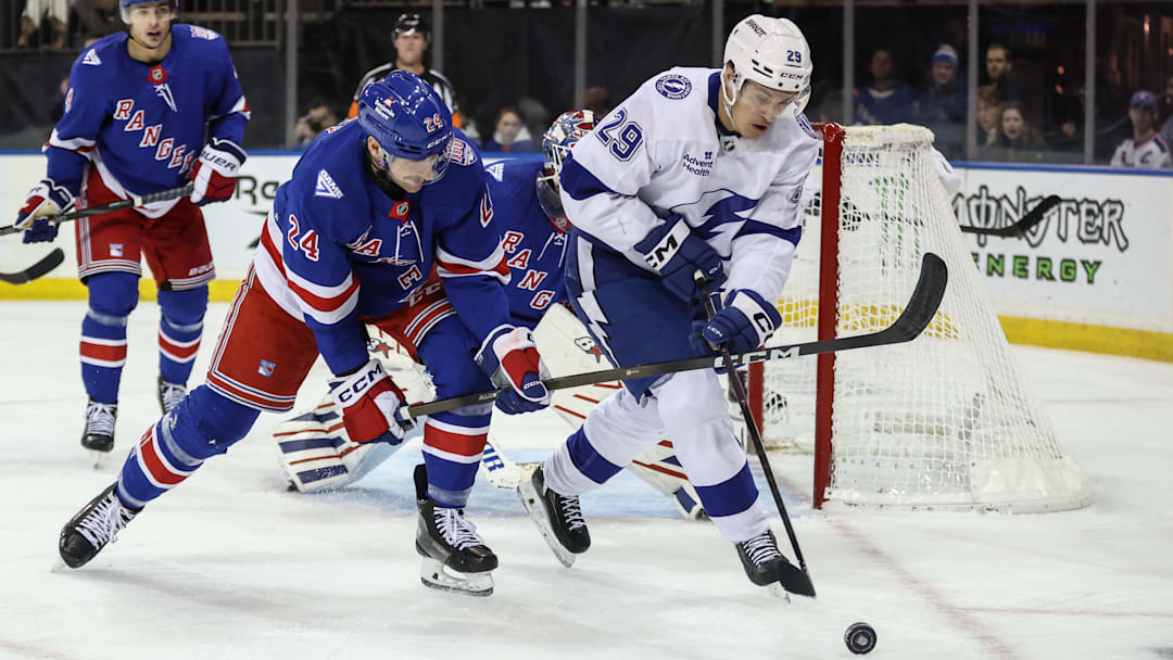 Nov 29, 2025; New York, New York, USA;  New York Rangers defenseman Carson Soucy (24) and Tampa Bay Lightning right wing Pontus Holmberg (29) battle for control of the puck at Madison Square Garden. Mandatory Credit: Wendell Cruz-Imagn Images