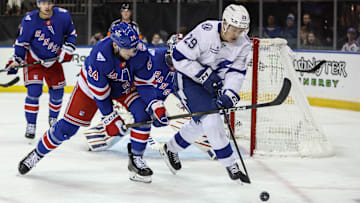 Nov 29, 2025; New York, New York, USA;  New York Rangers defenseman Carson Soucy (24) and Tampa Bay Lightning right wing Pontus Holmberg (29) battle for control of the puck at Madison Square Garden. Mandatory Credit: Wendell Cruz-Imagn Images