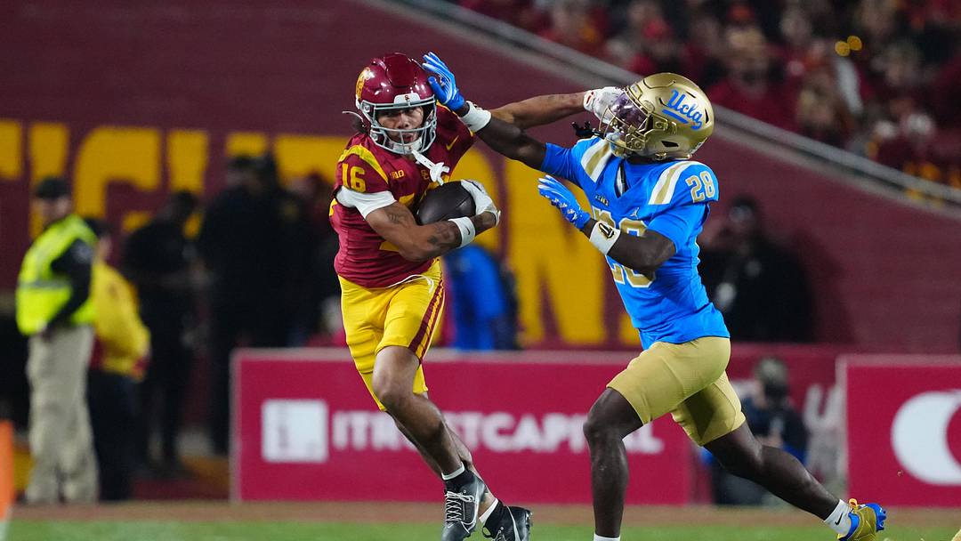 Nov 29, 2025; Los Angeles, California, USA; Southern California Trojans wide receiver Tanook Hines (16) carries the ball against UCLA Bruins defensive back Scooter Jackson (28) in the first half at United Airlines Field at Los Angeles Memorial Coliseum. Mandatory Credit: Kirby Lee-Imagn Images