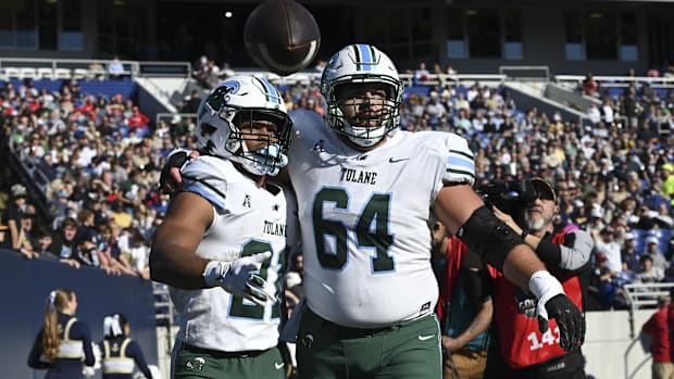 Tulane Green Wave running back Makhi Hughes celebrates with  offensive lineman Vincent Murphy.