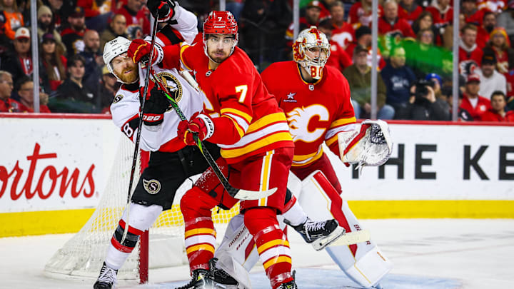 Dec 19, 2024; Calgary, Alberta, CAN; Calgary Flames defenseman Kevin Bahl (7) and Ottawa Senators right wing Claude Giroux (28) fights for position in front of Calgary Flames goaltender Dan Vladar (80) during the third period at Scotiabank Saddledome. Mandatory Credit: Sergei Belski-Imagn Images