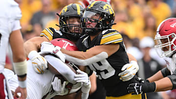 Sep 14, 2024; Iowa City, Iowa, USA; Troy Trojans running back Damien Taylor (3) is tackled by Iowa Hawkeyes defensive back Sebastian Castro (29) and defensive lineman Ethan Hurkett (49) as offensive lineman Tyler Cappi (65) looks on during the first quarter at Kinnick Stadium. Mandatory Credit: Jeffrey Becker-Imagn Images