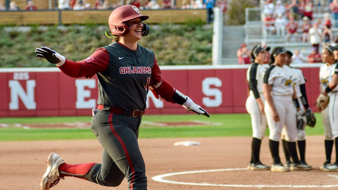 Oklahoma catcher Kendall Wells meets her teammates at the plate after blasting a home run. Oklahoma catcher Kendall Wells meets her teammates at the plate after blasting a home run.