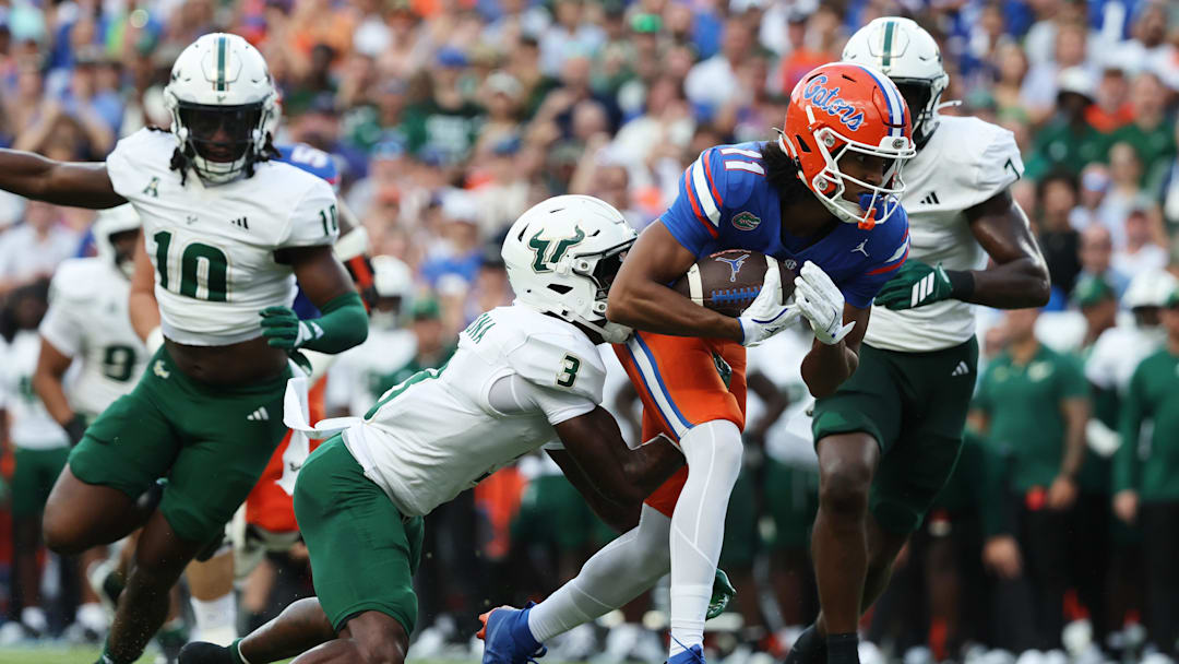 Sep 6, 2025; Gainesville, Florida, USA; Florida Gators wide receiver Aidan Mizell (11) runs with the ball as South Florida Bulls cornerback Jonas Duclona (3) tackles during the second quarter at Ben Hill Griffin Stadium. Mandatory Credit: Kim Klement Neitzel-Imagn Images