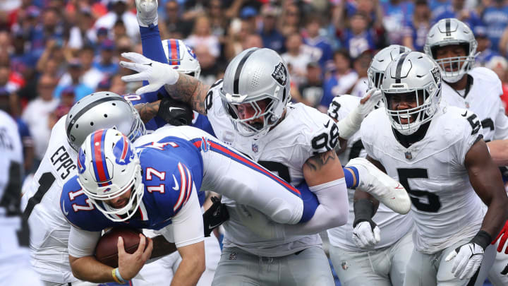 Bills quarterback Josh Allen tries to jump over the Raiders defensive line near the end zone.