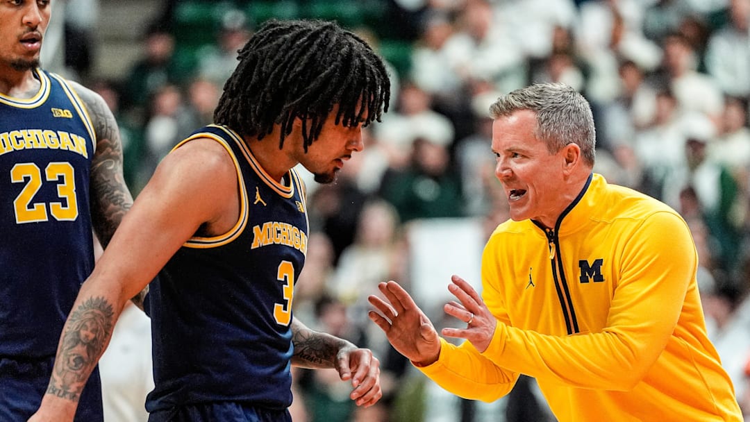 Michigan head coach Dusty May, right, talks to guard Elliot Cadeau (3), and forward Yaxel Lendeborg (23) before a play against Michigan State during the second half at Breslin Center in East Lansing on Friday, Jan. 30, 2026.