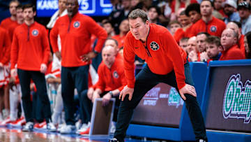 Mar 8, 2025; Lawrence, Kansas, USA; Arizona Wildcats coach Tommy Lloyd watches game play during the second half against the Kansas Jayhawks at Allen Fieldhouse. Mandatory Credit: William Purnell-Imagn Images
