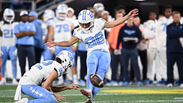 Dec 27, 2023; Charlotte, NC, USA; North Carolina Tar Heels place kicker Noah Burnette (98) kicks a field goal in the second quarter at Bank of America Stadium. Mandatory Credit: Bob Donnan-USA TODAY Sports