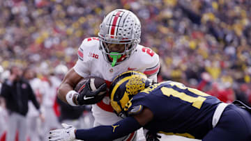 Nov 25, 2023; Ann Arbor, Michigan, USA; Ohio State Buckeyes wide receiver Emeka Egbuka (2) is hit by Michigan Wolverines defensive back Ja'Den McBurrows (18) as he scores a touchdown in the first half against the Michigan Wolverines at Michigan Stadium. Mandatory Credit: Rick Osentoski-USA TODAY Sports