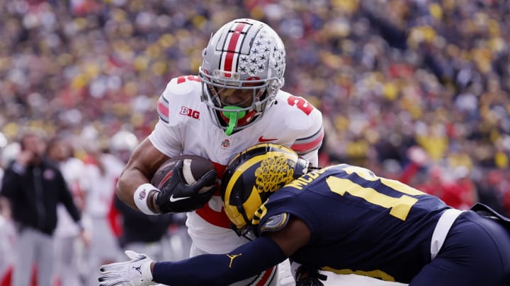 Nov 25, 2023; Ann Arbor, Michigan, USA; Ohio State Buckeyes wide receiver Emeka Egbuka (2) is hit by Michigan Wolverines defensive back Ja'Den McBurrows (18) as he scores a touchdown in the first half against the Michigan Wolverines at Michigan Stadium. Mandatory Credit: Rick Osentoski-USA TODAY Sports