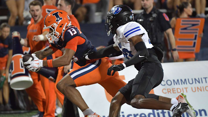 Aug 29, 2024; Champaign, Illinois, USA; Illinois Fighting Illini wide receiver Pat Bryant (13) scores a touchdown on a pass in front of Eastern Illinois Panthers defensive back Allen Brown III (30) during the first half at Memorial Stadium. Mandatory Credit: Ron Johnson-Imagn Images