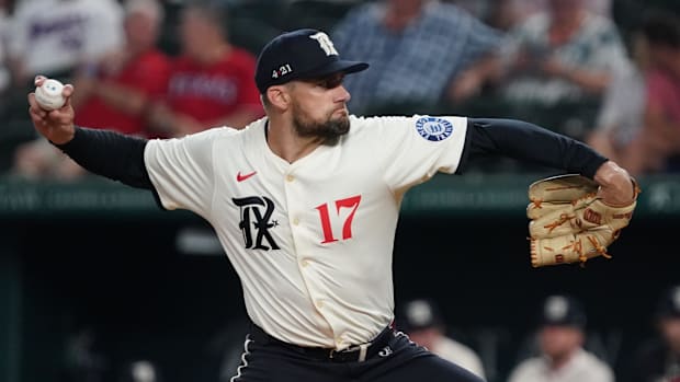 Texas Rangers starting pitcher Nathan Eovaldi throws in white uniform and black hat