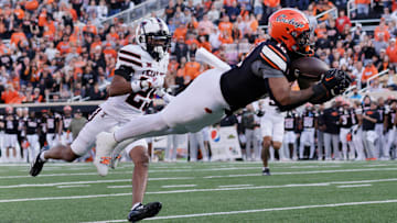 Oklahoma State's Rashod Owens catches a pass while Texas Tech's Chapman Lewis looks on during an NCAA football game on Saturday, Nov. 23, 2024, in Stillwater, Okla.