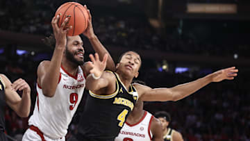 Dec 10, 2024; New York, New York, USA;  Arkansas Razorbacks forward Jonas Aidoo (9) and Michigan Wolverines guard Nimari Burnett (4) fight for a loose ball in the first half at Madison Square Garden. Mandatory Credit: Wendell Cruz-Imagn Images