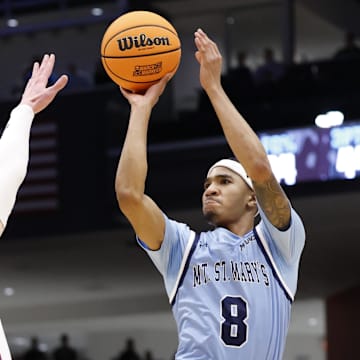 Mar 19, 2025; Dayton, OH, USA; Mount St. Mary's Mountaineers guard Dallas Hobbs (8) shoots the ball over American University Eagles forward Matt Rogers (15) in the first half at UD Arena. Mandatory Credit: Rick Osentoski-Imagn Images 