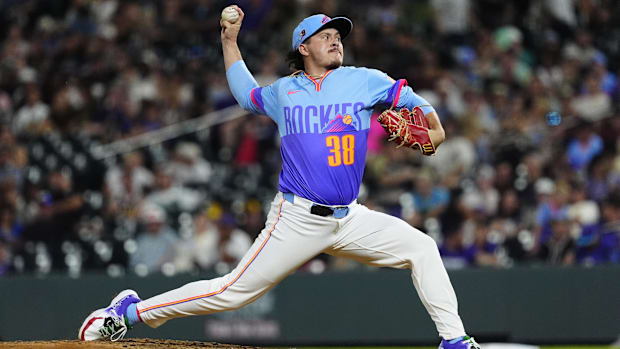 Top relief pitcher Vodnik throwing a ball in a light blue and purple jersey off the mound in white pant