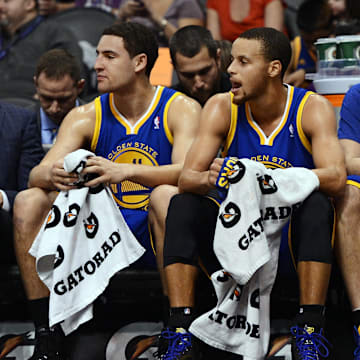 Dec 15, 2013; Phoenix, AZ, USA; Golden State Warriors guard Klay Thompson (left), guard Stephen Curry (left center) , forward David Lee (right center) and guard Kent Bazemore (right) watch from the bench in the first half against the Phoenix Suns at US Airways Center. The Suns defeated the Warriors 106-102. Mandatory Credit: Jennifer Stewart-Imagn Images