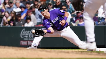 Apr 26, 2025; Denver, Colorado, USA; Colorado Rockies first base Michael Toglia (4) fields the ball in the sixth inning against the Cincinnati Reds at Coors Field. Mandatory Credit: Ron Chenoy-Imagn Images