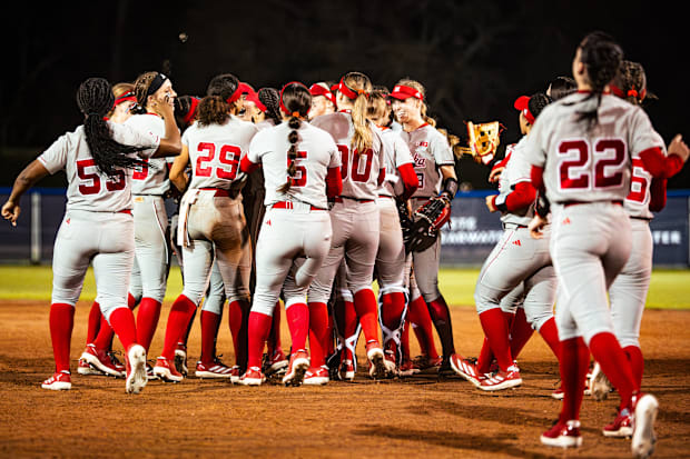 Nebraska softball players celebrate after beating No. 6 Tennessee to open the 2025 season.