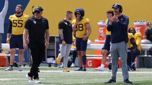 Former West Virginia University specialist Pat McAfee (right) and tight ends coach Blaine Stewart