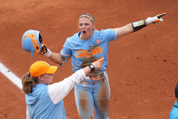 Tennessee utility Ella Dodge (25) and Tennessee softball head coach Karen Weekly gesture to the outfield to review.