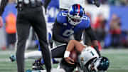 Oct 9, 2025; East Rutherford, New Jersey, USA; New York Giants linebacker Brian Burns (0) sacks Philadelphia Eagles quarterback Jalen Hurts (1) during the first quarter of the game at MetLife Stadium.  