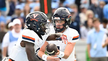 Oct 25, 2025; Chapel Hill, North Carolina, USA;  Virginia Cavaliers quarterback Chandler Morris (4) hands the ball off to wide receiver Andre Greene Jr. (2) in the third quarter at Kenan Stadium. Mandatory Credit: Bob Donnan-Imagn Images