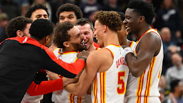 Trae Young #11 of the Atlanta Hawks is mobbed by teammates after his game-winning shot against the Utah Jazz.