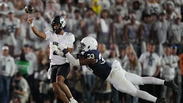 Sep 27, 2025; University Park, Pennsylvania, USA; Oregon Ducks quarterback Dante Moore (5) is tackled by Penn State Nittany Lions defensive end Dani Dennis-Sutton (33) during the first quarter at Beaver Stadium. Mandatory Credit: James Lang-Imagn Images