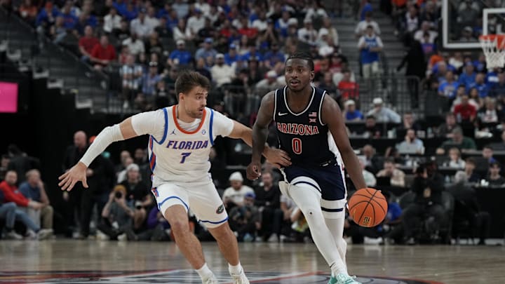 Nov 3, 2025; Las Vegas, NV, USA; Arizona Wildcats guard Jaden Bradley (0) dribbles against Florida Gators guard Urban Klavzar (7) during the second half of the Hall of Fame Series game at T-Mobile Arena. Mandatory Credit: Candice Ward-Imagn Images