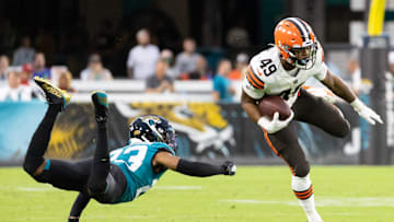 Aug 14, 2021; Jacksonville, Florida, USA; Cleveland Browns running back John Kelly (49) breaks a tackle by Jacksonville Jaguars cornerback C.J. Henderson (23) during the second quarter at TIAA Bank Field. Mandatory Credit: Matt Pendleton-Imagn Images