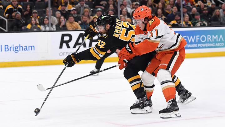 Oct 23, 2025; Boston, Massachusetts, USA; Boston Bruins center Sean Kuraly (52) shoots the puck while Anaheim Ducks defenseman Olen Zellweger (51) defends during the first period at TD Garden. Mandatory Credit: Bob DeChiara-Imagn Images