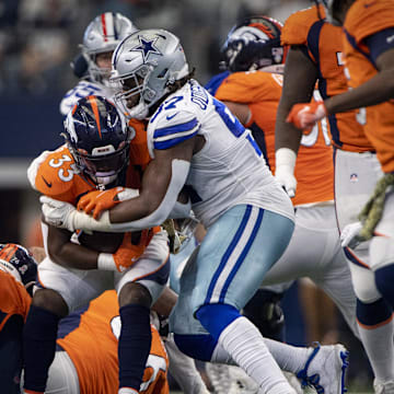 Nov 7, 2021; Arlington, Texas, USA; Denver Broncos running back Javonte Williams (33) is tackled by Dallas Cowboys defensive tackle Osa Odighizuwa (97) during the first quarter at AT&T Stadium. Mandatory Credit: Jerome Miron-Imagn Images