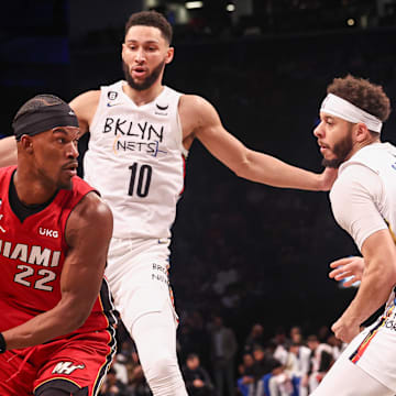 Feb 15, 2023; Brooklyn, New York, USA; Miami Heat forward Jimmy Butler (22) looks to pass as Brooklyn Nets guard Ben Simmons (10) and guard Seth Curry (30) defend during the first half at Barclays Center. Mandatory Credit: Vincent Carchietta-Imagn Images