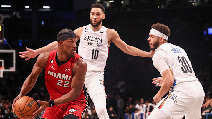 Feb 15, 2023; Brooklyn, New York, USA; Miami Heat forward Jimmy Butler (22) looks to pass as Brooklyn Nets guard Ben Simmons (10) and guard Seth Curry (30) defend during the first half at Barclays Center. Mandatory Credit: Vincent Carchietta-Imagn Images