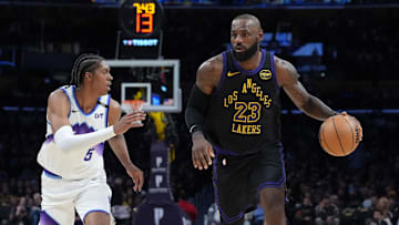 Lakers forward LeBron James dribbles the ball against Jazz forward Cody Williams.