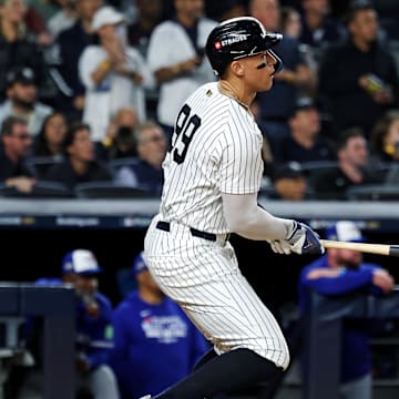 Oct 8, 2025; Bronx, New York, USA; New York Yankees right fielder Aaron Judge (99) hits a single during the first inning against the Toronto Blue Jays during game four of the ALDS round for the 2025 MLB playoffs at Yankee Stadium. Mandatory Credit: Vincent Carchietta-Imagn Images