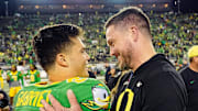 Oregon quarterback Dillon Gabriel, left, and coach Dan Lanning embrace after defeating Maryland at Autzen Stadium.