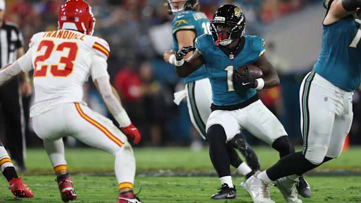 Oct 6, 2025; Jacksonville, Florida, USA; Jacksonville Jaguars running back Travis Etienne (1) runs against Kansas City Chiefs linebacker Drue Tranquill (23) during the first quarter at EverBank Stadium.