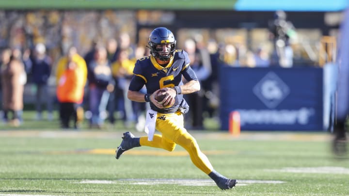 Nov 18, 2023; Morgantown, West Virginia, USA; West Virginia Mountaineers quarterback Garrett Greene (6) runs for extra yards during the first quarter against the Cincinnati Bearcats at Mountaineer Field at Milan Puskar Stadium. 