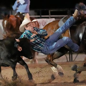 July 10, 2025; Tuscaloosa, AL, USA; A steer evades Lex Owens as he competes in the steer wrestling event during the 17h Annual Sokol Park Rodeo in the Ray C. Jenkins Arena.