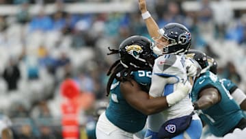 Dec 29, 2024; Jacksonville, Florida, USA; Jacksonville Jaguars defensive tackle DaVon Hamilton (52) tackles Tennessee Titans quarterback Mason Rudolph (11) during the first quarter  at EverBank Stadium. Mandatory Credit: Morgan Tencza-Imagn Images