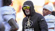 Nov 23, 2024; Kansas City, Missouri, USA;  Colorado head coach Deion Sanders watches his players warmup prior to the game between the Kansas Jayhawks and the Colorado Buffaloes at GEHA Field at Arrowhead Stadium. Mandatory Credit: Nick Tre. Smith-Imagn Images