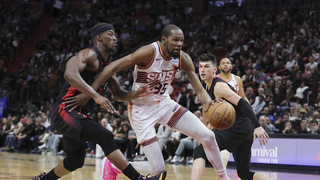 Jan 29, 2024; Miami, Florida, USA; Phoenix Suns forward Kevin Durant (35) moves to the basket past Miami Heat forward Jimmy Butler (22) and guard Tyler Herro (14) during the second quarter at Kaseya Center. Mandatory Credit: Sam Navarro-Imagn Images