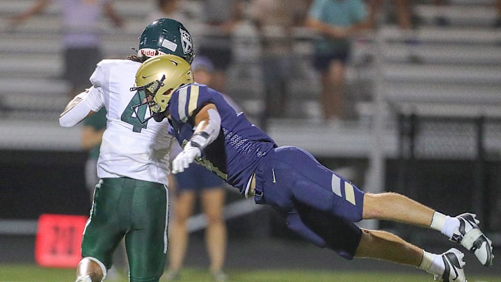 Hoban linebacker Tanner Mintz makes a diving tackle on Trinity Episcopal School's Davion Brown, Saturday, Sept. 2, 2023.