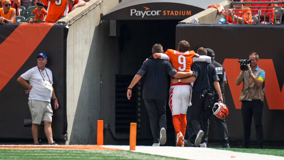 Cincinnati Bengals quarterback Joe Burrow is assisted to the locker room