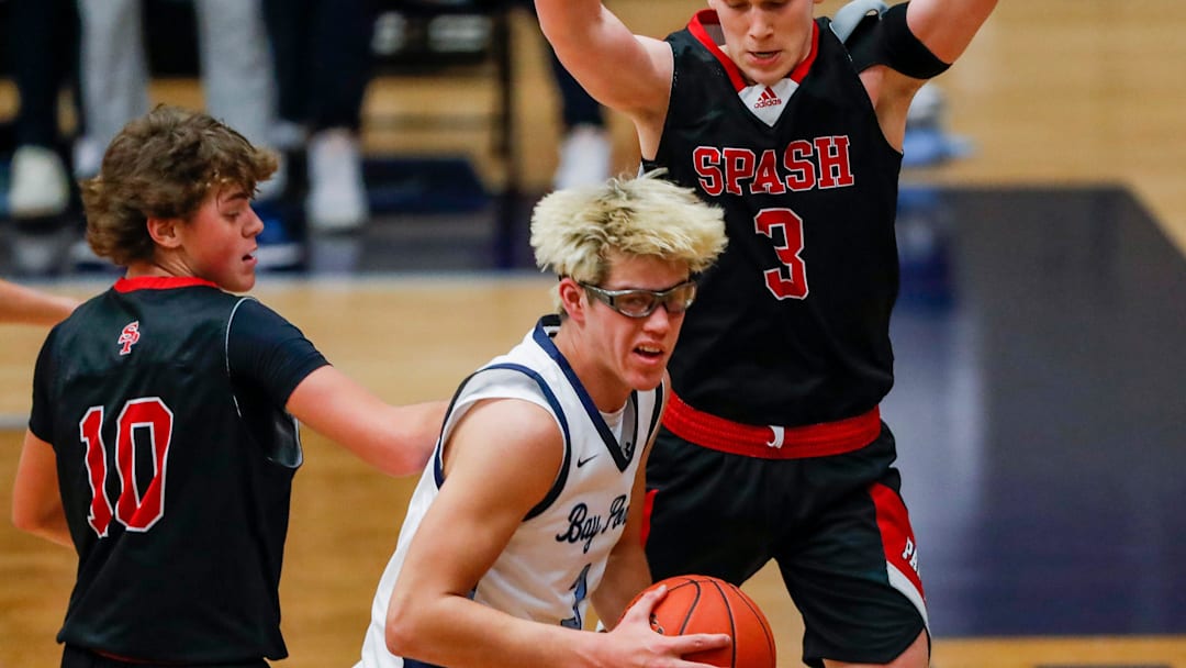 SPASH’s Sam Kornowski (10) and Trent Chandonais (3) defend Bay Port High School's Matt Stevens (3) on Tuesday, December 2, 2025, at Bay Port High School in Suamico, Wis. Bay Port won the game, 62-59, on a buzzer-beater by AJ Ivy.
Tork Mason/USA TODAY NETWORK-Wisconsin