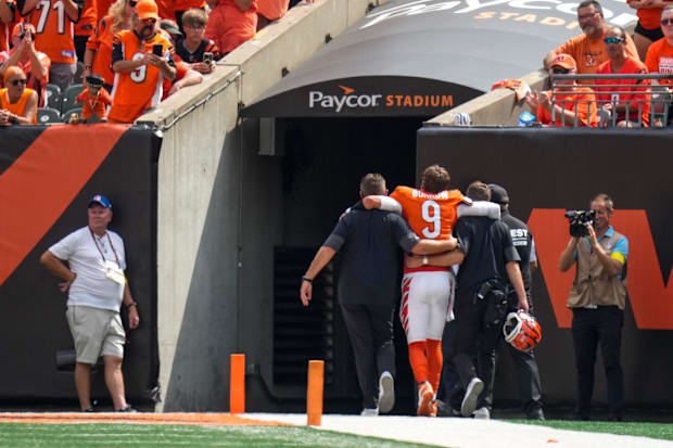 Cincinnati Bengals quarterback Joe Burrow (9) is assisted to the locker room after his toe injury against the Jaguars.